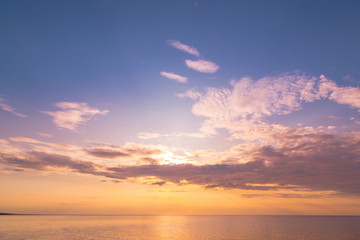Calm sea with sunset sky and sun through the clouds over. Meditation ocean and sky background. Tranquil seascape. Horizon over the water.