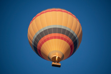 Naklejka premium Cappadocia, Turkey, Europe: a traditional hot air balloon floating after dawn in the sky over the valley of Cavusin in the historical region in Central Anatolia rich of exceptional natural wonders