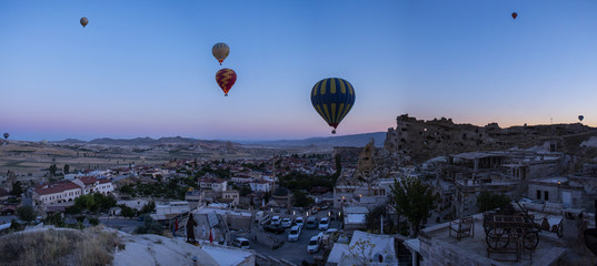 Cappadocia, Turkey: hot air balloons floating at dawn on the church of St. John the Baptist (Cavusin castle), famous 5th century cave church on top of the hill of the old town of Cavusin 
