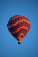 Cappadocia, Turkey, Europe: a traditional hot air balloon floating after dawn in the sky over the valley of Cavusin in the historical region in Central Anatolia rich of exceptional natural wonders