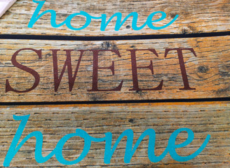 Lettering Home sweet home on a textured old blackboard with brown and yellow tint