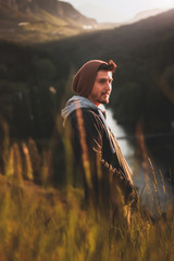 joven en el atardecer con pastos altos y luz calida