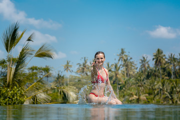 Woman playing with water in the swimming pool