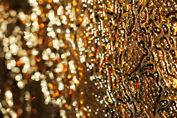 Colored glass. Gold and brown background. The texture of the glass. Yellow patterns. Design.
