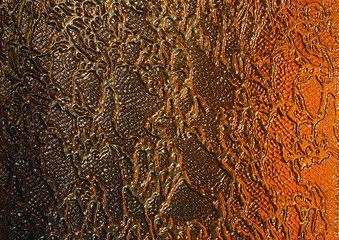 Colored glass. Gold and brown background. The texture of the glass. Yellow patterns. Design.