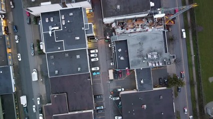 Construction site view from the top with the crane and roofs of buildings around