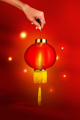 Hand holding glowing Chinese lantern