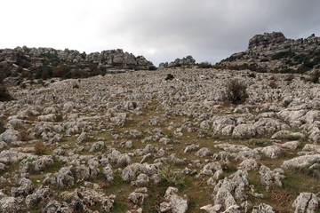 Fototapeta na wymiar View on a hill being covered with tons of fractured rock pieces surrounded by larger limestone rocks in the impressive rock landscape of El Torcal de Antequera, Spain, Europe