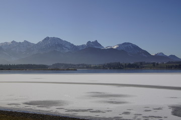 Blick über den Hopfensee in Richtung winterlicher Alpen