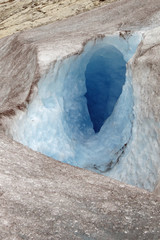 Macro of a hole / crevasse in drop form in the blue ice at the Nigardsbreen glacier in Norway, Europe