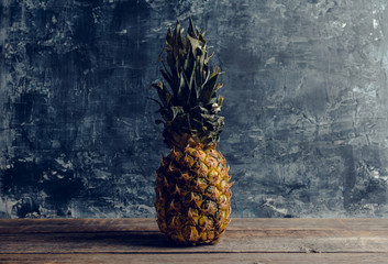 Fresh ripe pineapple on the rustic background. Selective focus.