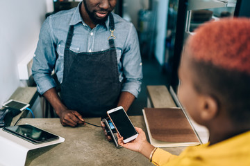Man accepting payment from female client in cafe