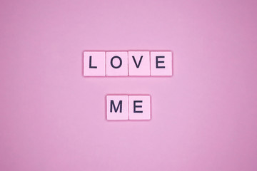 Love me word wooden cubes on a pink background