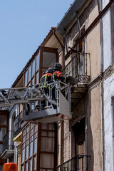 Fototapeta na wymiar Firefighters uploaded on an elevating platform, attending an emergency