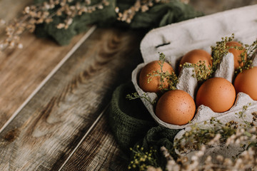 Eggs in a box on a wooden background decorated in a rustic style