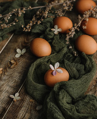 Eggs without staining on a wooden background in gauze in a rustic style