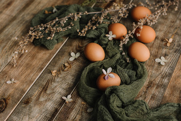 Eggs without staining on a wooden background in gauze in a rustic style