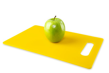 Green Apple on Yellow Cutting Board White Background