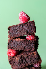 Stack of brownies with frozen raspberries. Chocolate cake pile