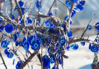 Tree decorated with the eye-shaped amulets made of blue glass. Turkish traditional souvenir. Cappadocia. Goreme.