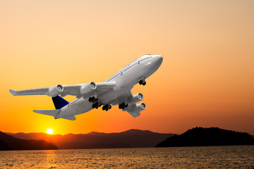Commercial airplane flying above clouds in dramatic sunset light
