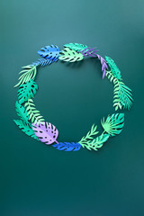 tropical leaves cut from paper on green background.