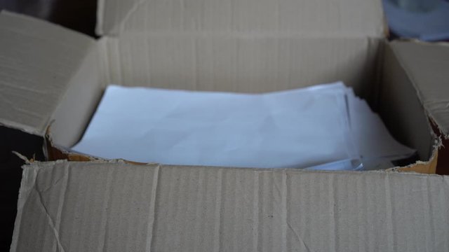 Putting a heap of used paper into a cardboard box