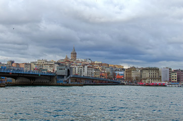 Fototapeta na wymiar Istanbul, Turkey-January 03, 2020: Picturesque landscape view of Istanbul. The Galata Bridge over the Golden Horn in Istanbul. The Galata Tower (Christea Turris) at the top of the hill