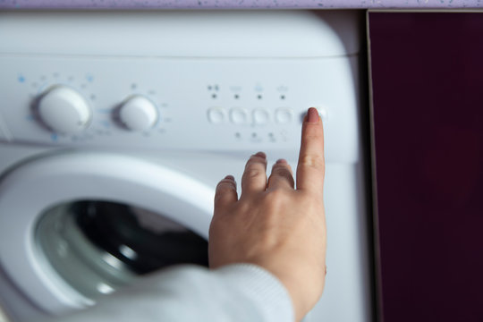 woman hand in washing machine