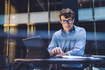 Young male reading documents at workplace
