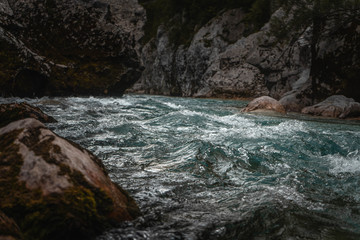 moody fast river soca in Slovenia with rocks