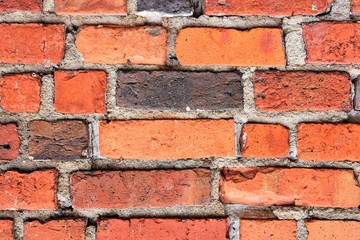 Obraz premium Grunge red brick wall with textured blocks, selective focus. Old stone wall. Red bricks background. Construction works. Brickwork. 
