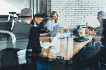 Diverse partners cooperating in office room