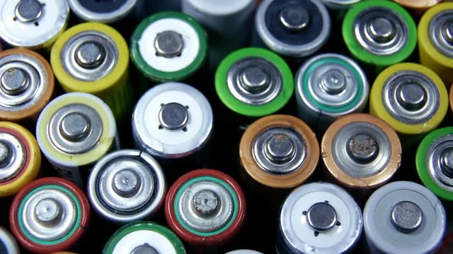 Different types of used batteries in heap. High danger for the environment. Batteries background