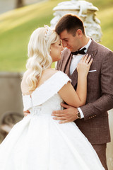Naklejka premium Full length body portrait of young bride and groom running on green grass of golf course, back view. Happy wedding couple walking through golf course, copy space