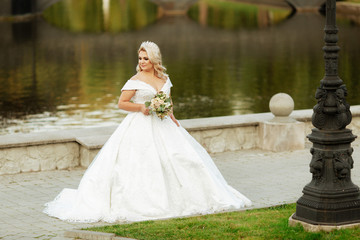 Girl with white hair said on the nature, in the forest, on the lake. Wedding dress.