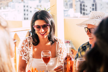 Couple of adult cheerful happy woman enjoying together lunch time outdoor at the restaurant - middle age and senior ladies smile and have fun with food and drinks