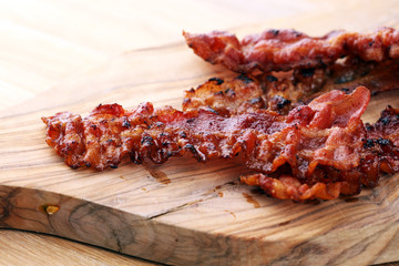 Closeup of slices of crispy hot freshly cooked bacon for tasty breakfast