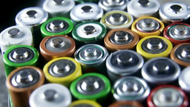 Collection of old used AAA batteries. High danger for the environment. Batteries background