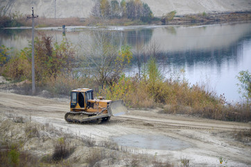 Quarry aggregate with heavy duty machinery. Caterpillar loader Excavator with backhoe driving to...