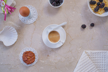 Breakfast with fruits and coffee on a marble table.