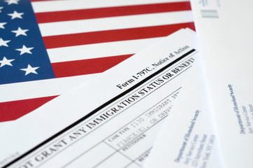 I-797c Notice of action blank form lies on United States flag with envelope from Department of...