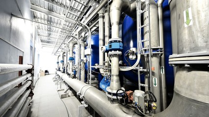 New shiny pipes, large pumps in industrial boiler room, close-up. Industry, technology, special...