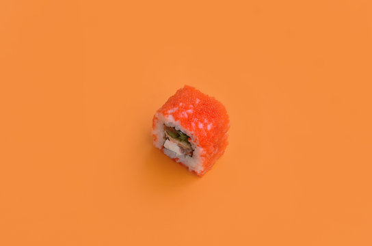California Maki sushi roll with caviar on orange background. Minimalism top view flat lay with Japanese food