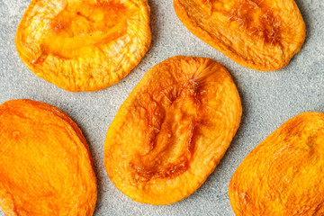 Dried delicious peaches on a gray concrete or stone background. An ingredient for making sweet dishes. Useful fruit. Healthy snack. Selective focus, top view