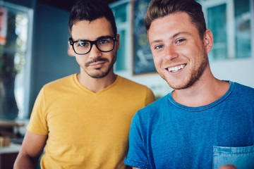 Satisfied male spending time with friend in cafeteria