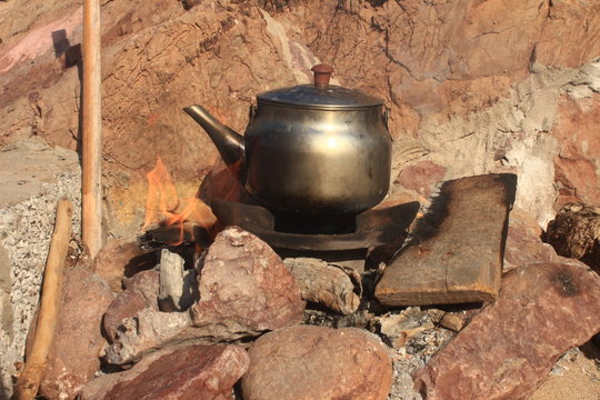 teapot on fire between stones