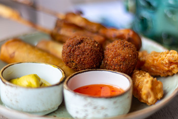 Dutch snacks for beer or wine, tempura shrimps, skewered chicken, bitterballs and hot dip sauces