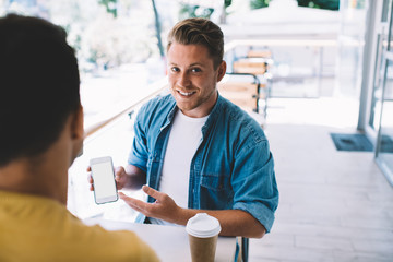 Young man showing mobile phone