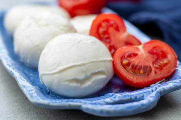 Cheese collection, fresh Italian soft mozzarella cheese in balls served with red ripe tomatoes
